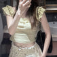 Model wearing the Sweet Clover Ruffle Top with cream polka-dot ruffled bottoms and a black chain shoulder bag.