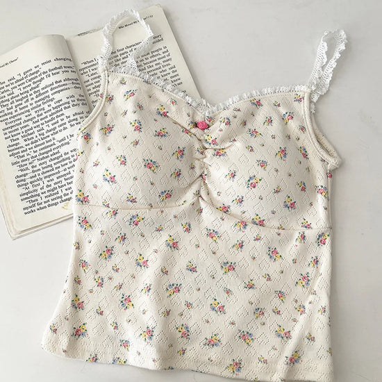 Flatlay of cream Sweet Flower Crop Top with multicolor mini floral print and hot pink center flower.