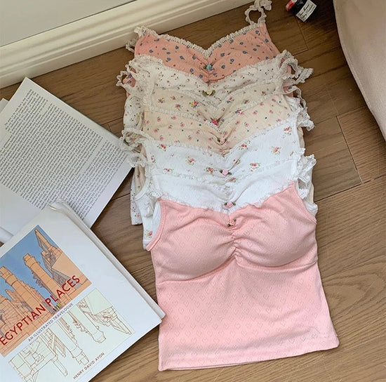 Full range of Sweet Flower Crop Tops in floral and heart prints arranged on a wooden floor.