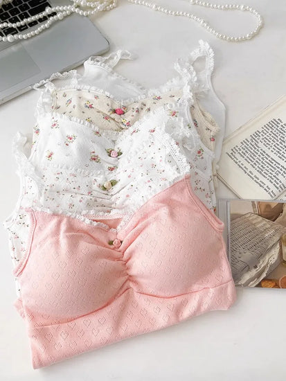 Stacked Sweet Flower Crop Tops in floral and heart prints with lace trim, styled beside pearls and a book.