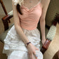 Model seated in chair wearing pink Sweet Flower Crop Top with ruched bust and lace straps, paired with a white ruffled skirt.