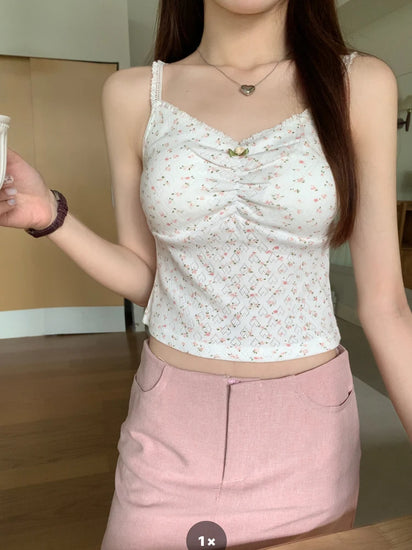 Close-up of a model wearing white Sweet Flower Crop Top with pink floral print and ruched bust detail.