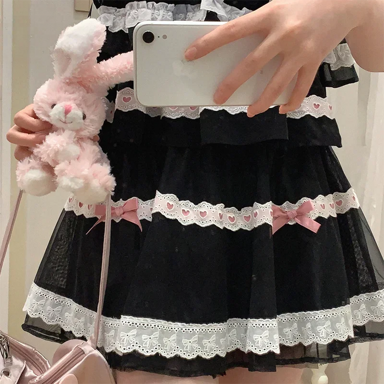 Close-up photo of a model wearing the black and pink Sweet Love Lace Bow Skort.