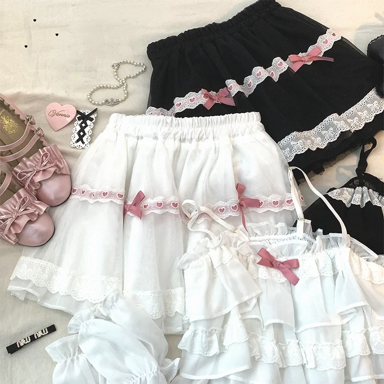 Close-up of the white/pink and black/pink Sweet Love Lace Bow Skort color options displayed next to matching tops.