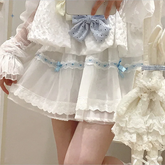 Front view of the white and blue Sweet Love Lace Bow Skort, featuring layered mesh, heart lace trim, and blue bow and ribbon accents.