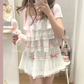 Model wearing the white and pink Sweet Love Lace Bow Skort with a matching layered top.
