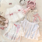 Flat lay of the white and pink Sweet Love Lace Bow Skort with two matching tops.