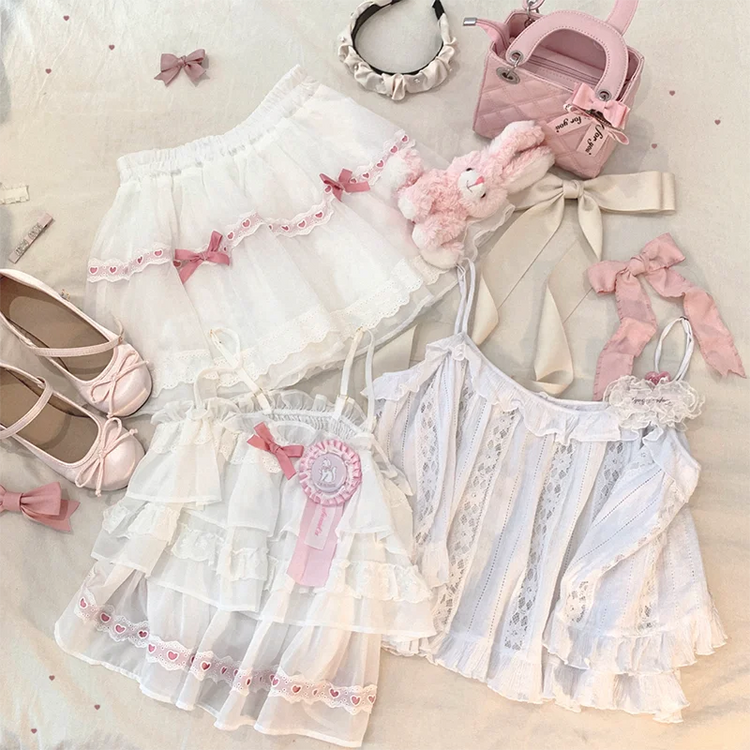 Flat lay of the white and pink Sweet Love Lace Bow Skort with two matching tops.