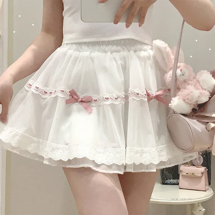 Front view of the white and pink Sweet Love Lace Bow Skort, featuring layered mesh, heart lace trim, pink bow accents, and a mini A-line silhouette.