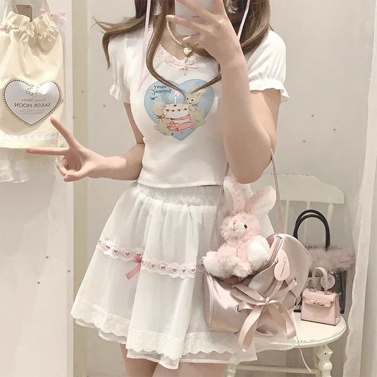 Front view of the white and pink Sweet Love Lace Bow Skort styled with a fitted graphic tee.