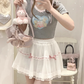 Model wearing the white and pink Sweet Love Lace Bow Skort with a gray top for a sweet coquette look.