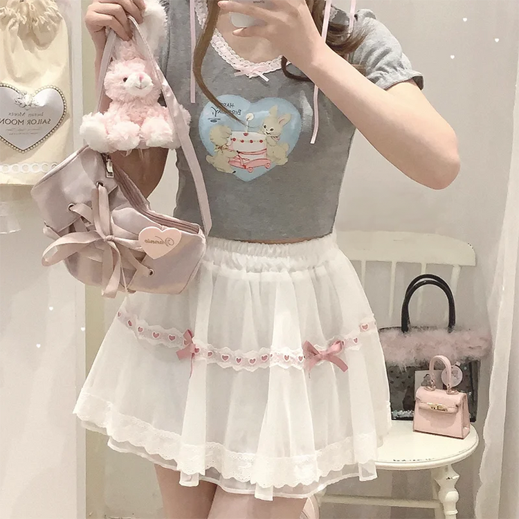 Model wearing the white and pink Sweet Love Lace Bow Skort with a gray top for a sweet coquette look.