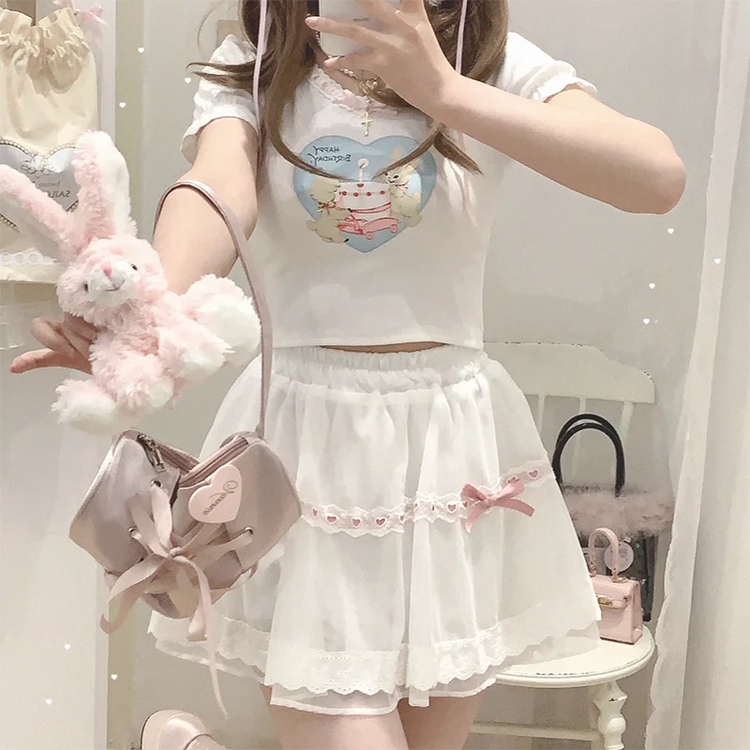 Model wearing the white and pink Sweet Love Lace Bow Skort styled with a plush bunny bag and casual top.