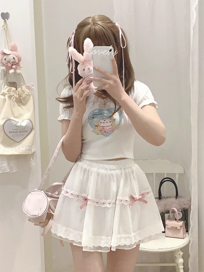 Mirror selfie of the white and pink Sweet Love Lace Bow Skort, showcasing the layered mesh and mini silhouette.