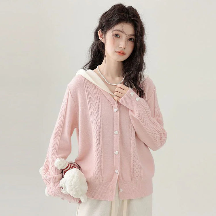 Model wearing the Sweetheart Cable Knit Cardigan, showing its V-neck open front and cream knit hood.