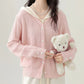 Sweetheart Cable Knit Cardigan in light pink displayed from the front, showing its V-neck open front and cream knit hood.