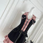 Angled front view of the Sweetheart Stitch Denim Dress in black denim with a pink plaid center panel.