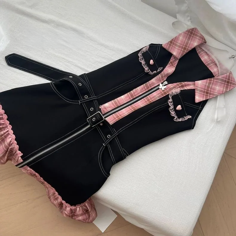 Sweetheart Stitch Denim Dress laid flat on a bed, showing its belted waist and pink plaid trim.