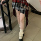 Angled view of model in the Tilted Temper Tartan Skirt, showing movement of the layers