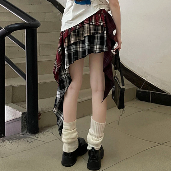 Model wearing the Tilted Temper Tartan Skirt standing, showing the back of the skirt