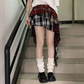 Model wearing the Tilted Temper Tartan Skirt standing straight, showing asymmetrical layers