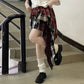 Side angle of model in the Tilted Temper Tartan Skirt, showing different lengths of the layers