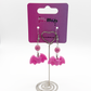 Two Moody Originals Candy Bite Bat Earrings hot pink version displayed on stand