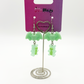 Two Moody Originals Candy Bite Bat Earrings mint version displayed on stand