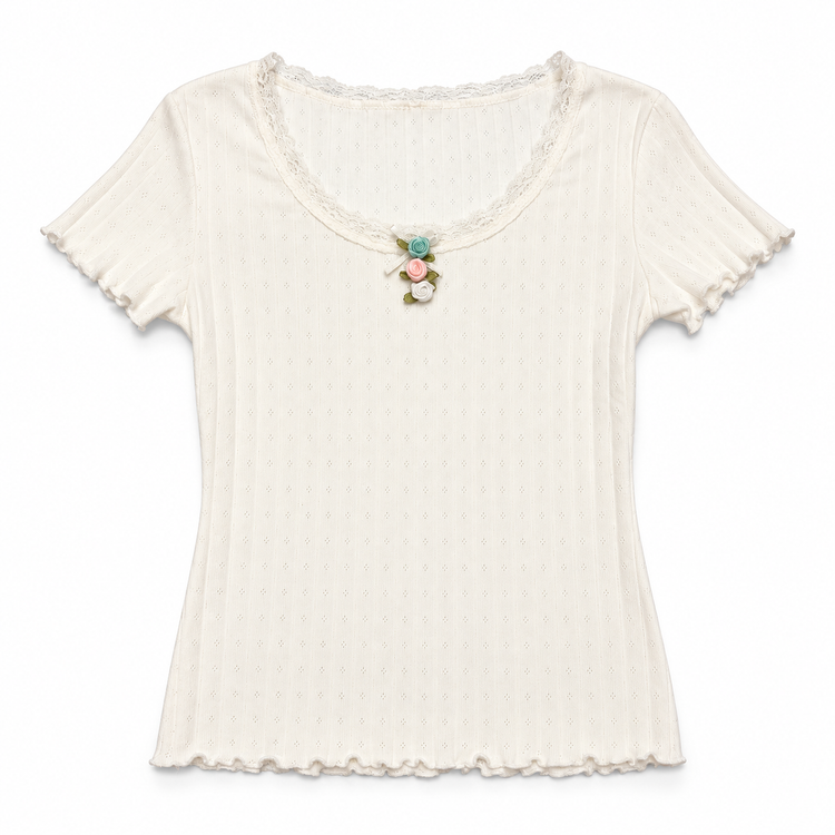 Front flat lay of the white Soft Dreams Two Moody Originals: Floral Daydream Top with a vertical row of multicolor rose appliqués and a bow. 
