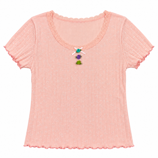 Front flat lay of the pink Vivid Dreams Two Moody Originals: Floral Daydream Top with a vertical row of multicolor rose appliqués and a bow. 
