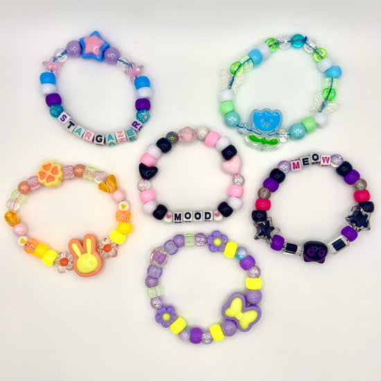 Multiple styles of Two Moody Originals: Kandi Bracelets pictured in a flat lay