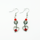 Two Moody Originals: Lovestruck Charm Earrings with transparent smoky black beads, red-orange crystal accents, silver heart charms, and red crystal centers.