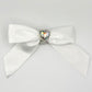 Front of the large decorated Two Moody Originals: Signature Bow Clips in the color white with a heart rhinestone center