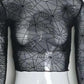 Close-up of the Web of Shadows Mesh Top, highlighting the sheer black spiderweb mesh pattern and fitted silhouette.
