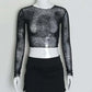 Front view of the Web of Shadows Mesh Top, showcasing the sheer black spiderweb mesh, cropped silhouette, and full-length sleeves.