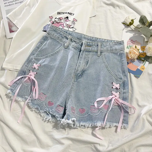 Front flat lay of Wildly Lovable Party Animal Shorts with pink lace-up ribbons and animal and heart embroidery