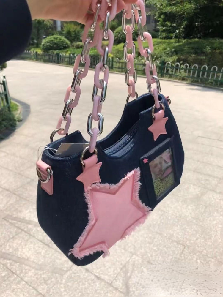 Side-angle view of the Y2K Harajuku Star Denim Chain Bag in dark blue showing the pink star appliqué, chunky chain handle, zipper, and shoulder strap.