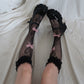 Close-up of the black Kawaii Lace Bow Fishnet Stockings featuring fishnet stockings with dotted heart motifs, lace ruffle cuffs, and pink dotted lace bow accents.