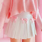 Angled side view of the Sweetheart Academy Skort showing the flared pleats and pink bows