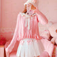 Full outfit with the Sweetheart Academy Skort, a cozy pink sweater, and a fuzzy white bucket hat in a pink bedroom setting
